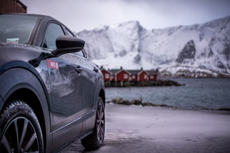 a black car parked in front of a row of red buildings