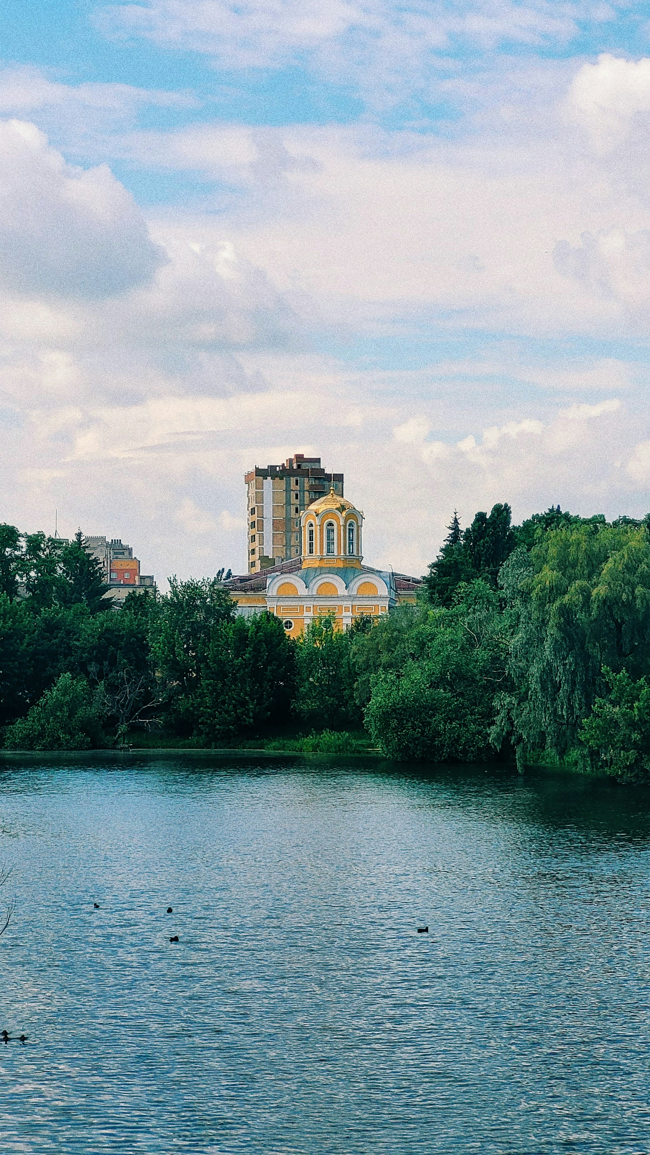 a building on a hill by a body of water