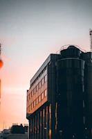 Ultra-realistic image of a modern luxury residential development at sunset with golden light reflecting on sleek architecture.