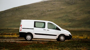 a white van parked on a dirt road