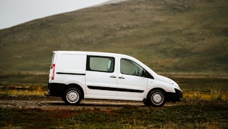 a white van parked on a dirt road