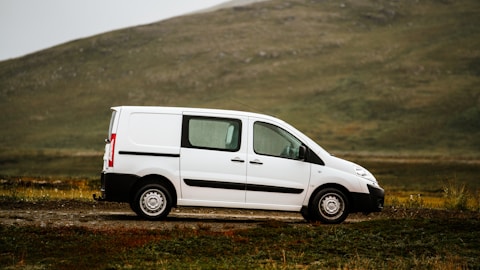 a white van parked on a dirt road