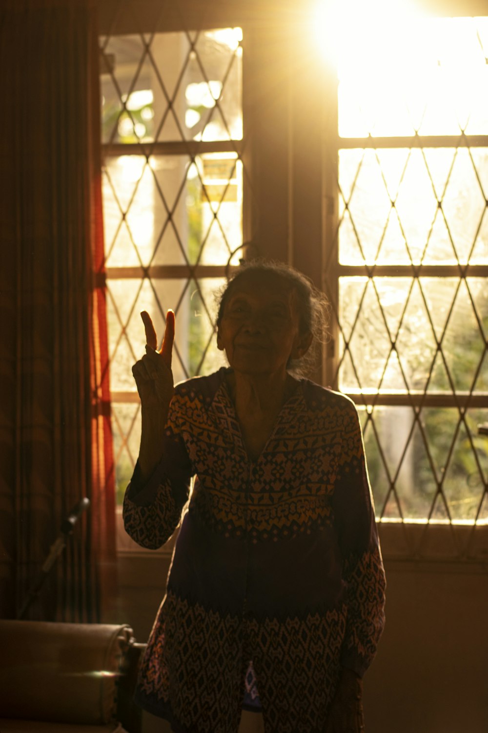 a person standing in front of a window with the hand up