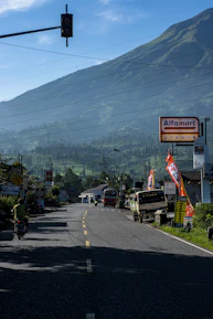 A fleet of clean, modern vehicles ready for rental with scenic Lombok hills in the background.
