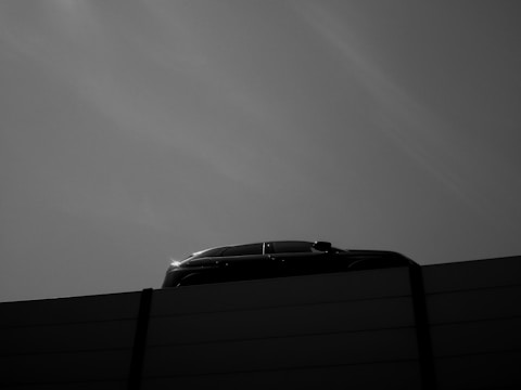 Abstract minimalist car silhouette with clean lines on a light background.