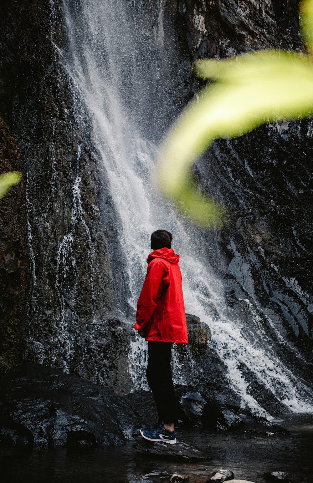 Una persona parada frente a una cascada