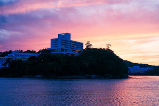 a building on a hill by the water