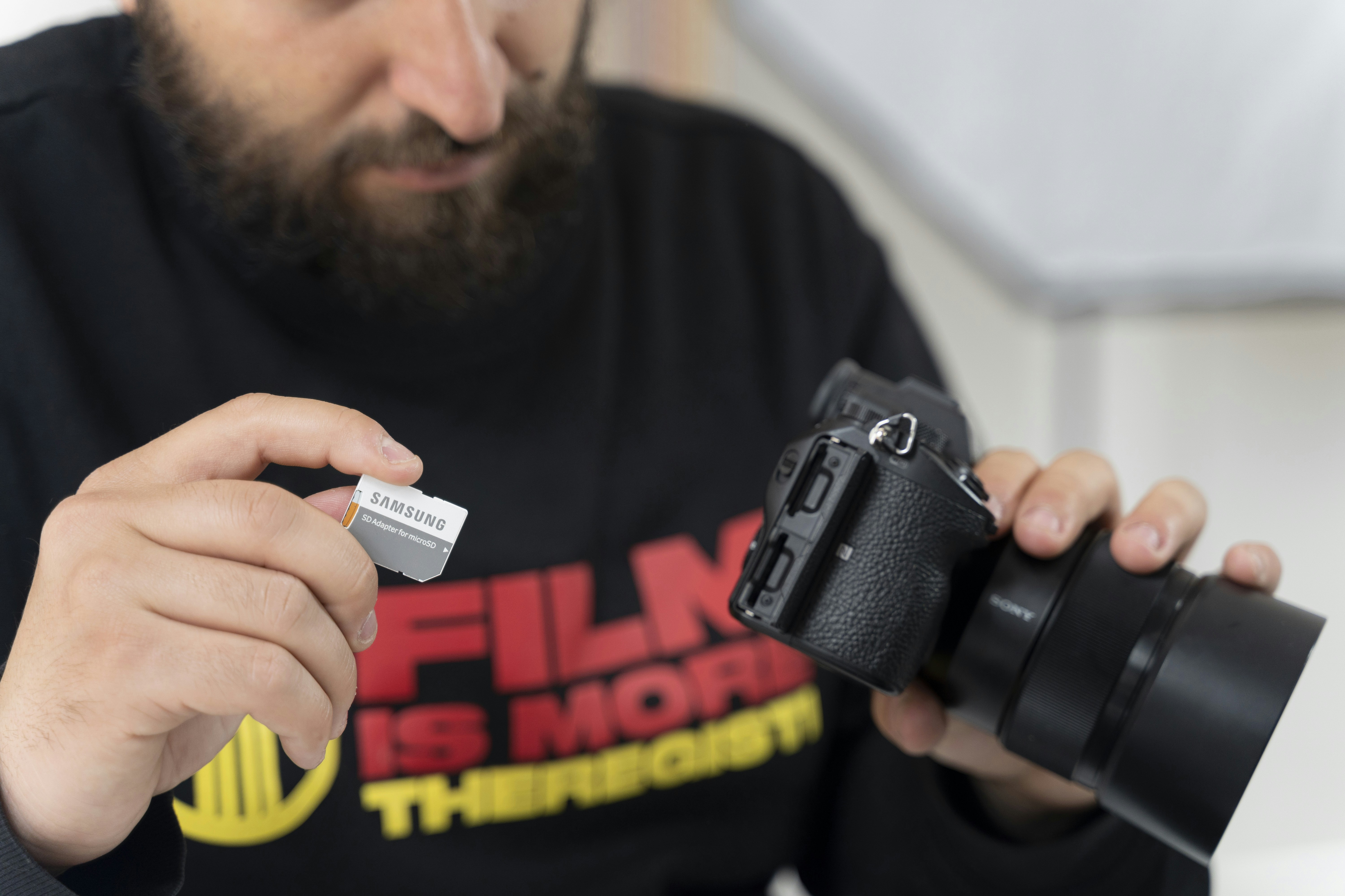 Photographer at work insert SD cart into camera