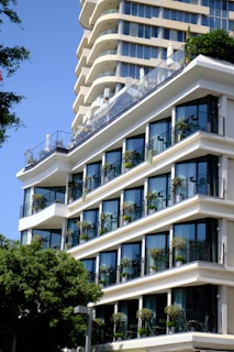 a building with balconies and trees in front of it