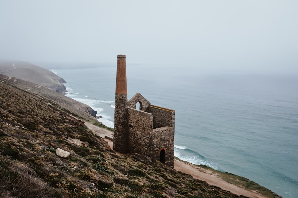 a stone building on a cliff by the ocean