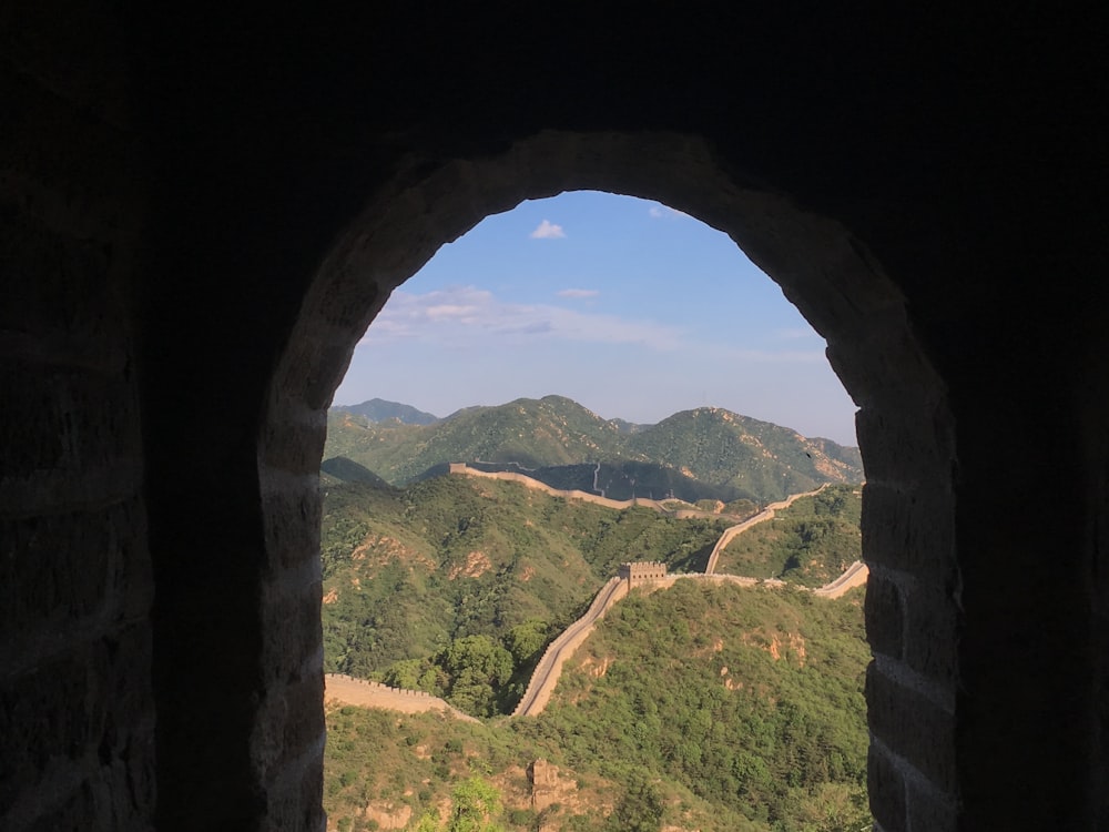 a view of a valley through a stone archway