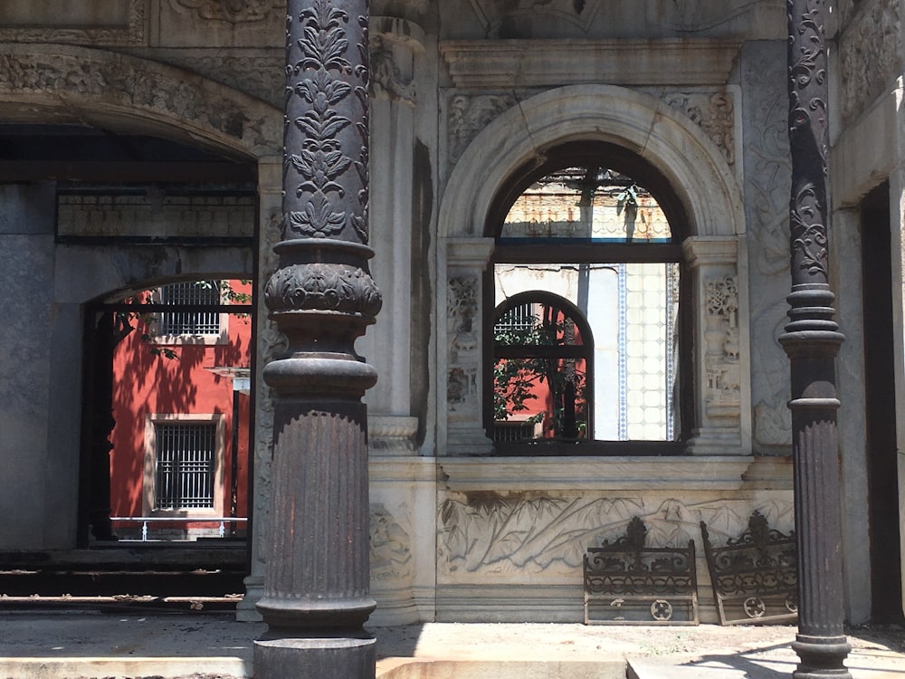 a couple of windows with a red curtain in the front