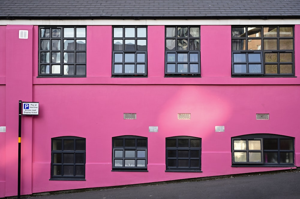 Ein rosa Gebäude mit Fenstern