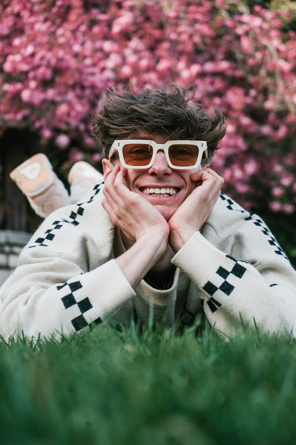 a person lying in the grass with the hands on the face