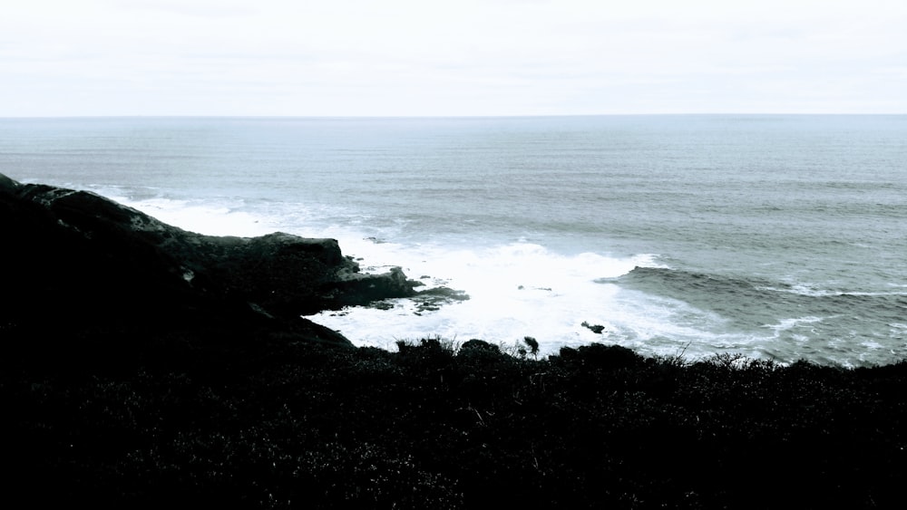 a rocky beach with waves crashing against it