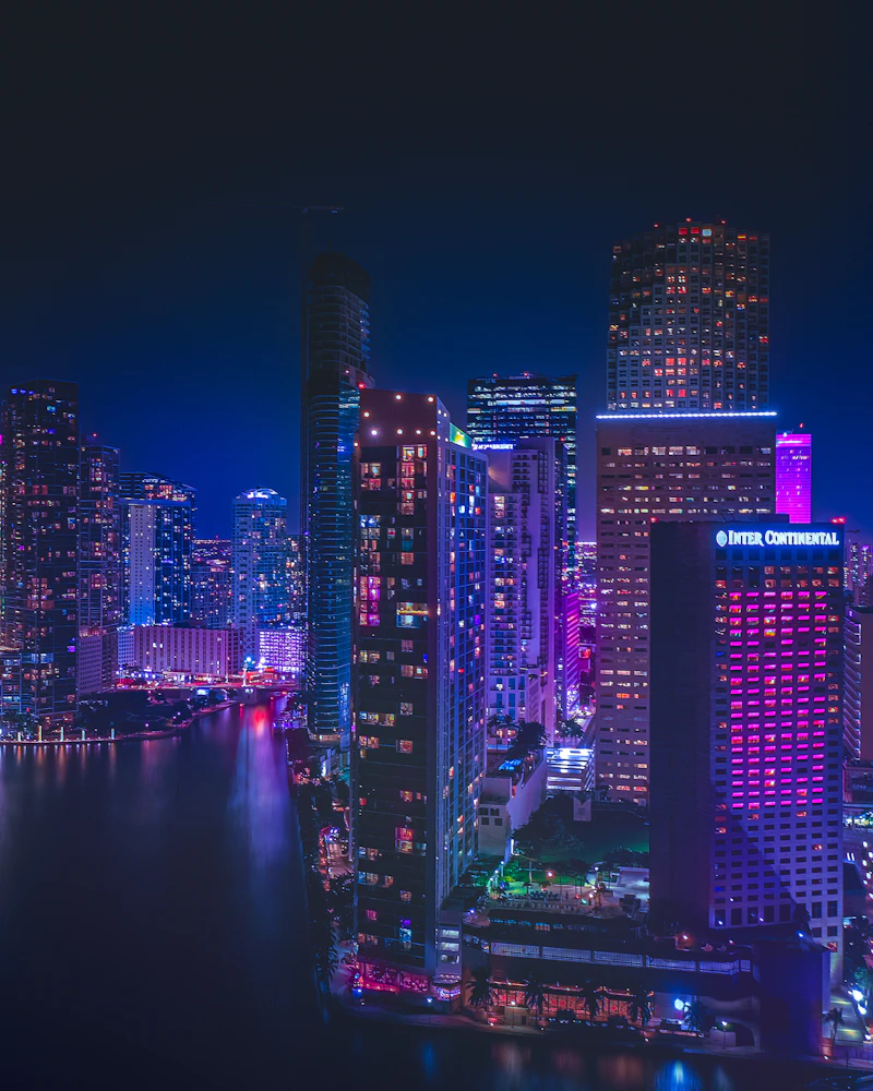 Downtown Miami skyscrapers illuminated at night along the bay