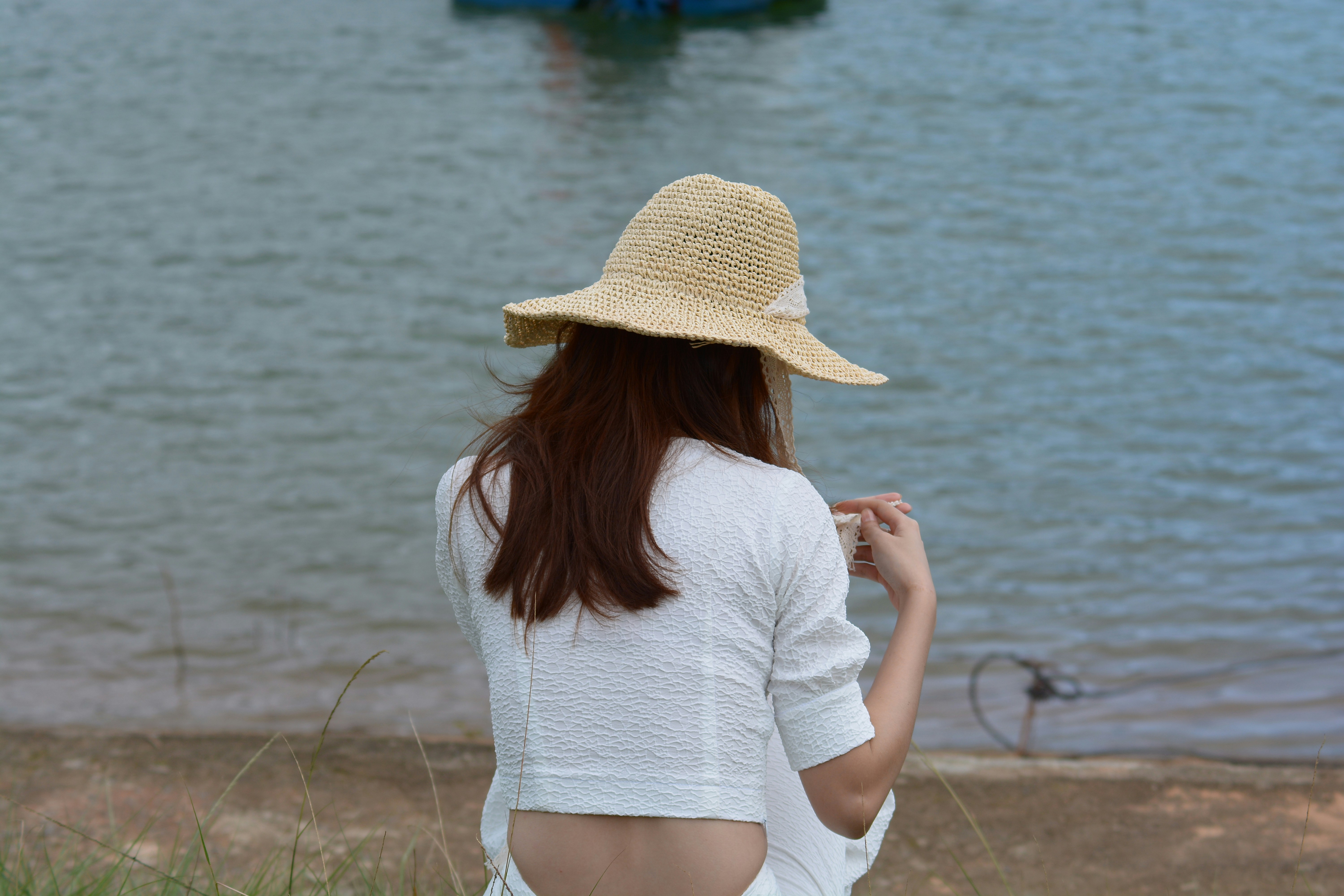 a person in a hat looking at a body of water
