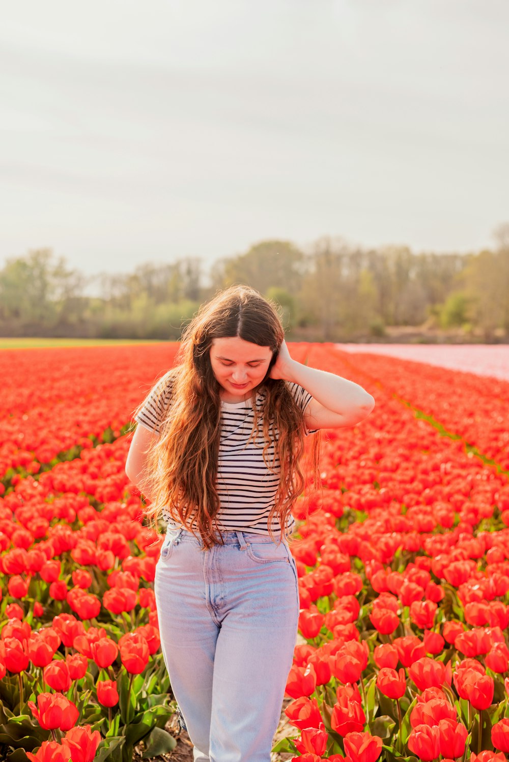 Eine Person, die in einem Feld mit roten Blumen steht