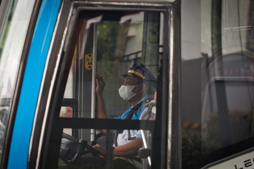 a person in a mask sitting on a bus