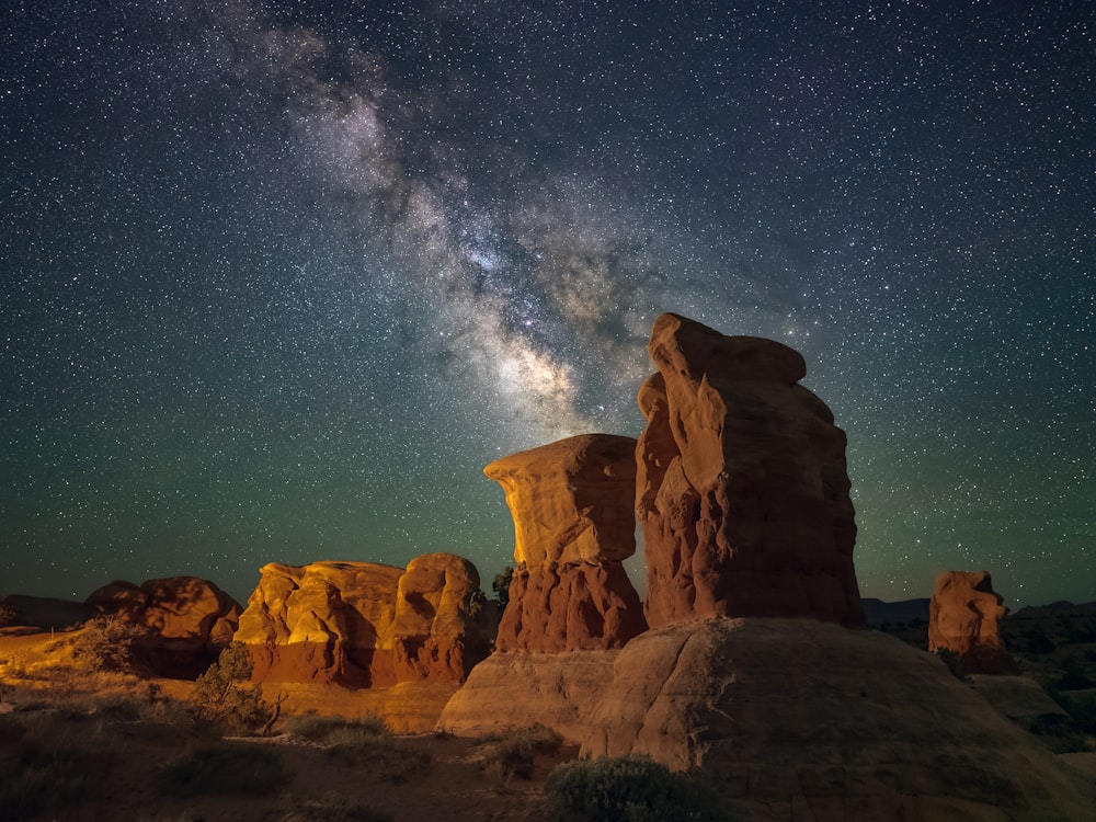 a rocky mountain with a starry sky above