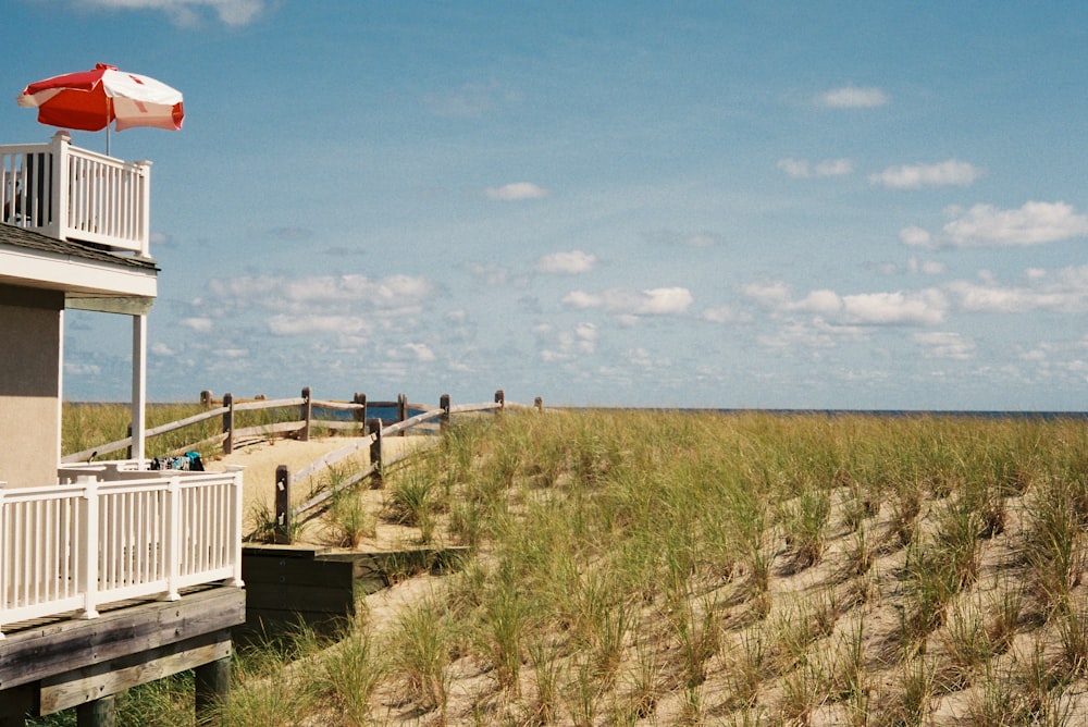 a grassy area with a building and a body of water in the background