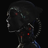 A silhouette of a human-like figure with cybernetic elements, featuring illuminated circuits and lights. The profile is dark with prominent bright accents highlighting the futuristic design.