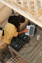 A content creator wearing headphones, focused on mixing tracks in a cozy home studio.