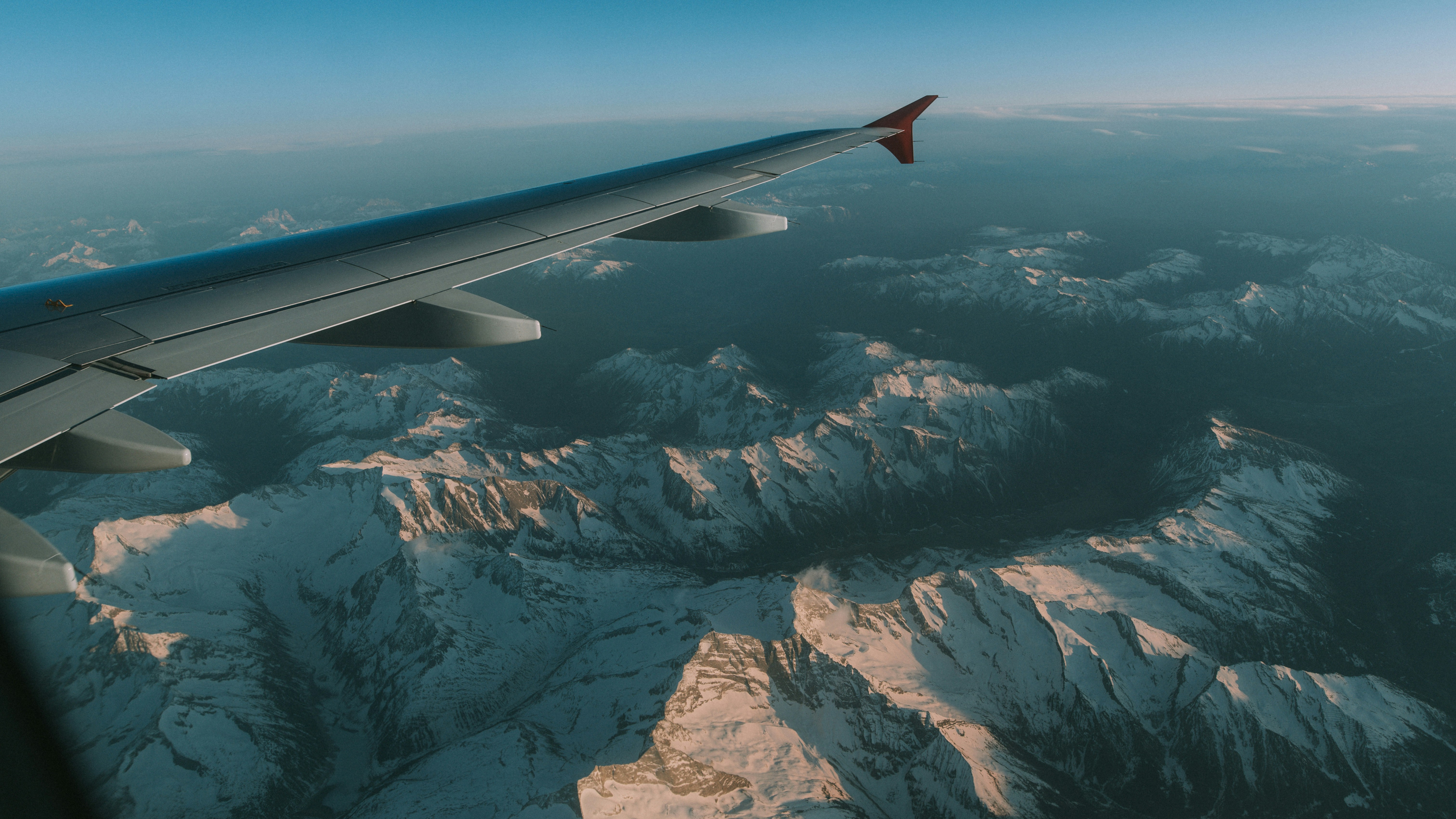 an airplane wing over a mountain range