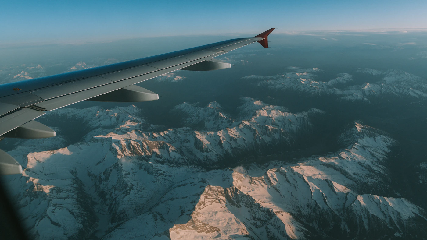 Airplane wing over a mountain range