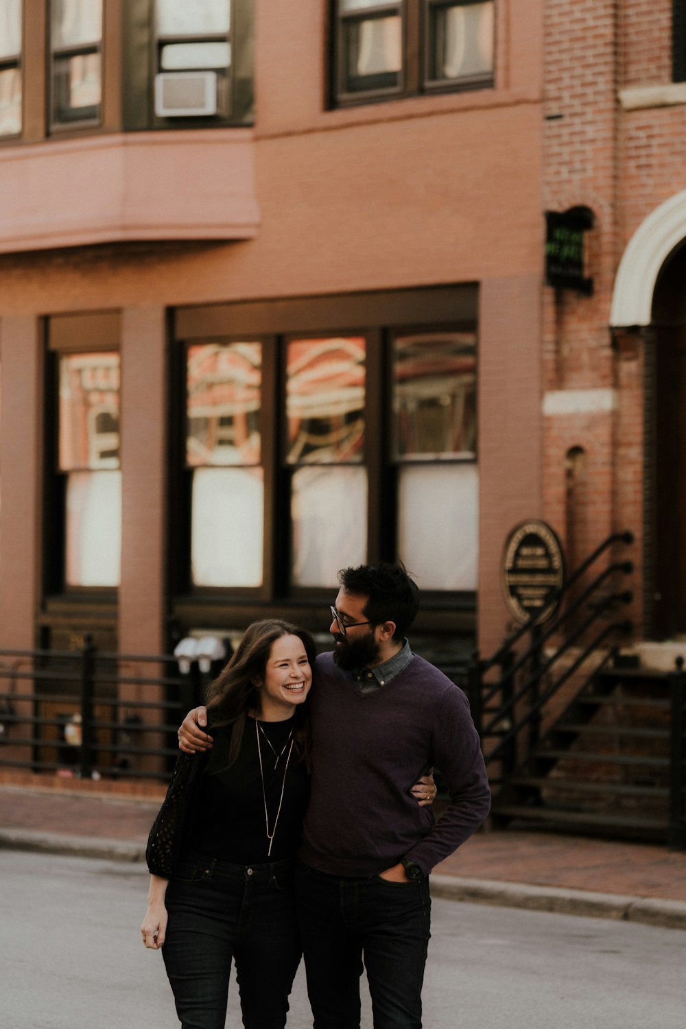 a man and woman posing for a picture outside of a building