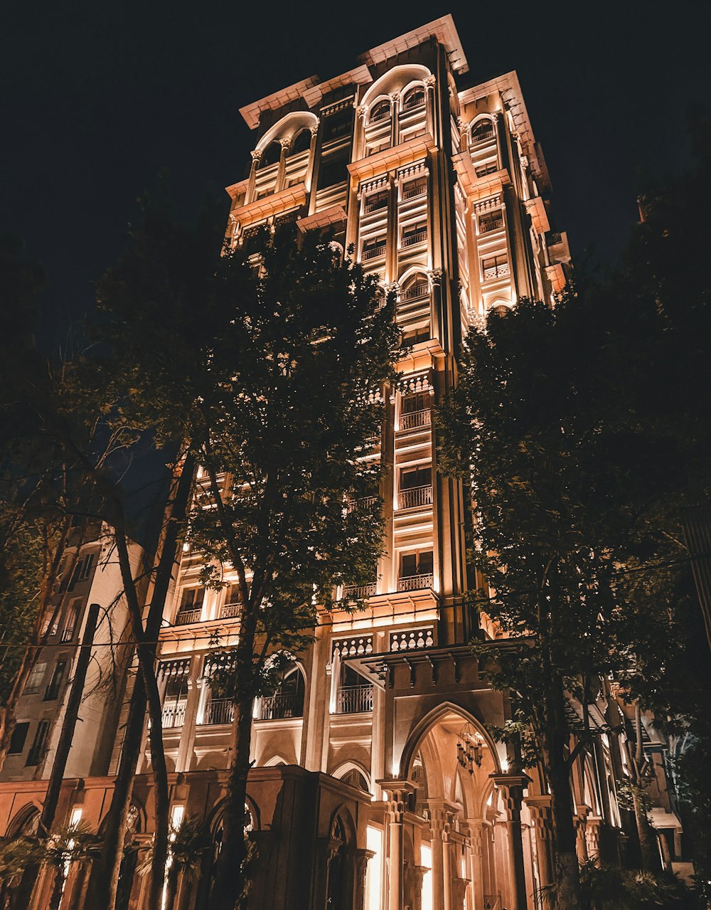 a tall building with trees in front of it