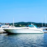 A sleek white yacht docked at Surf City marina under a clear blue sky.