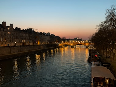a river with a bridge and buildings along it