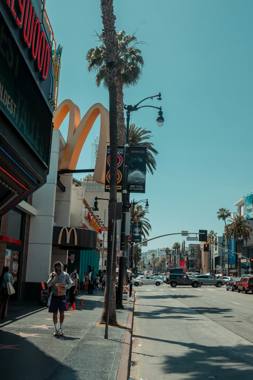 a street with palm trees and people