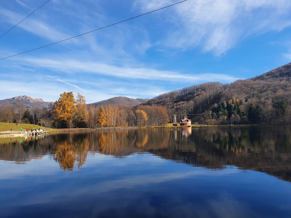 Un lago con árboles y montañas al fondo