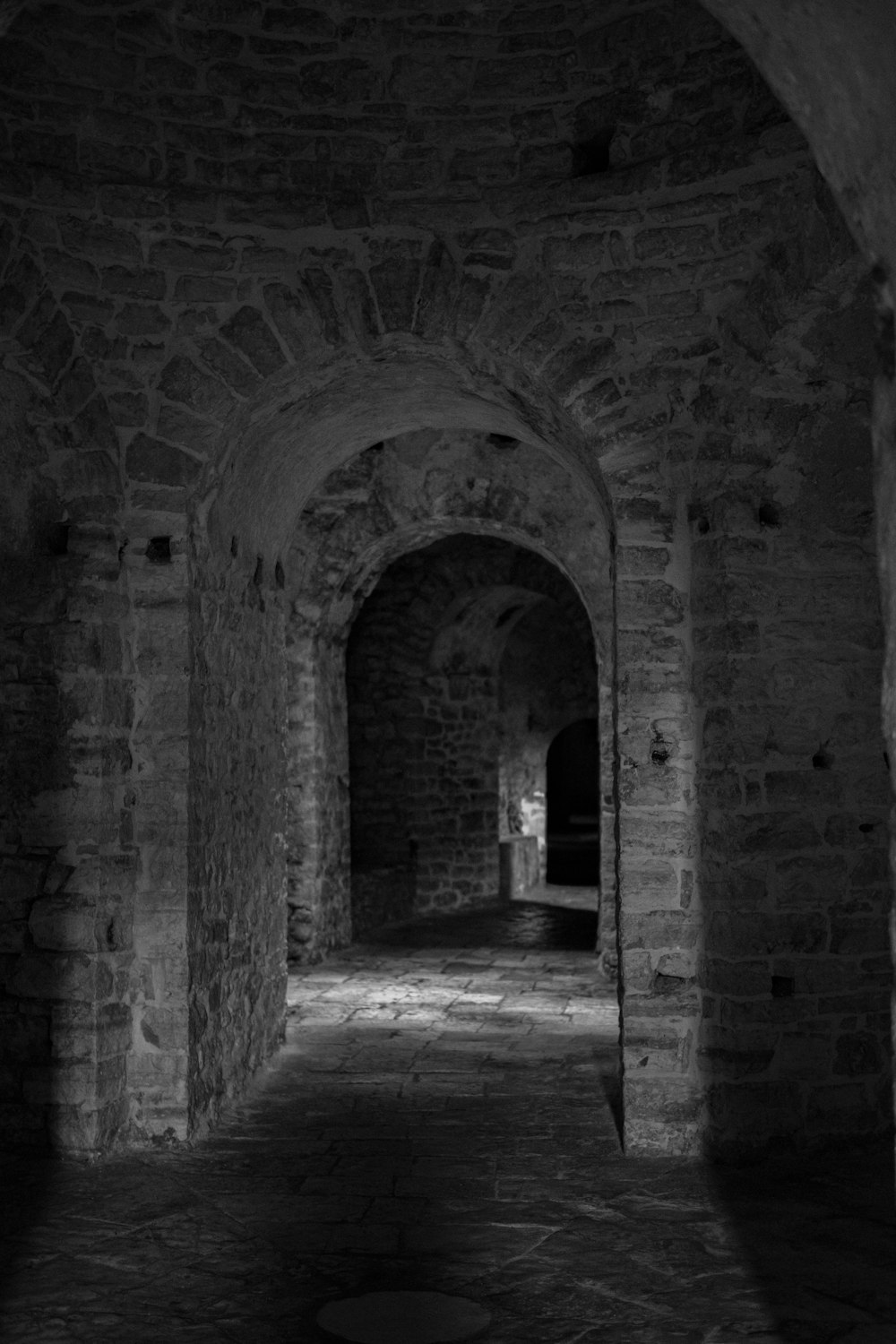 a stone hallway with a stone archway