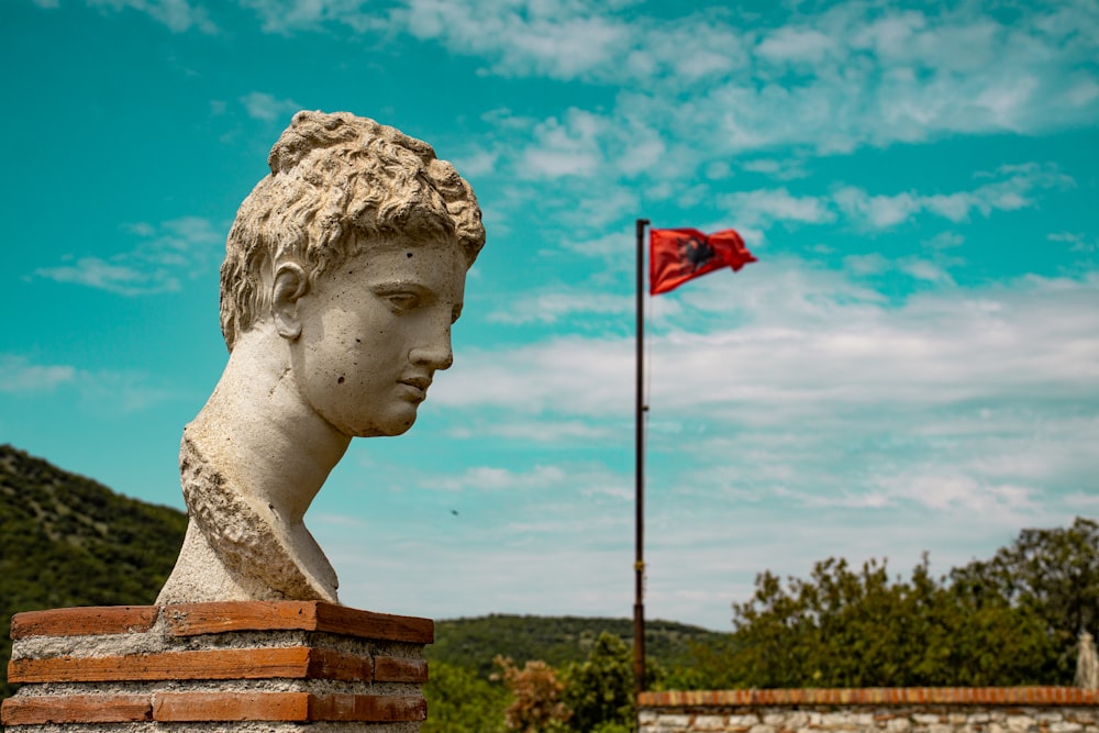a statue of a person with a flag in the background