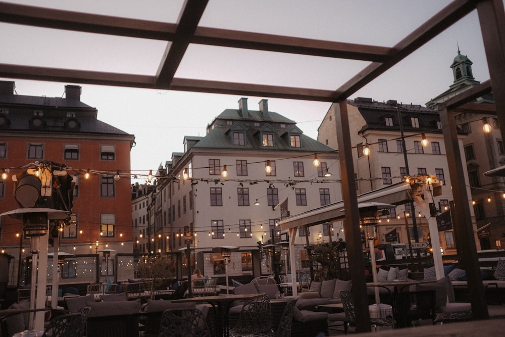 a group of buildings with tables and chairs outside