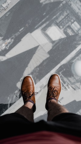 a pair of feet with sandals on a patterned surface