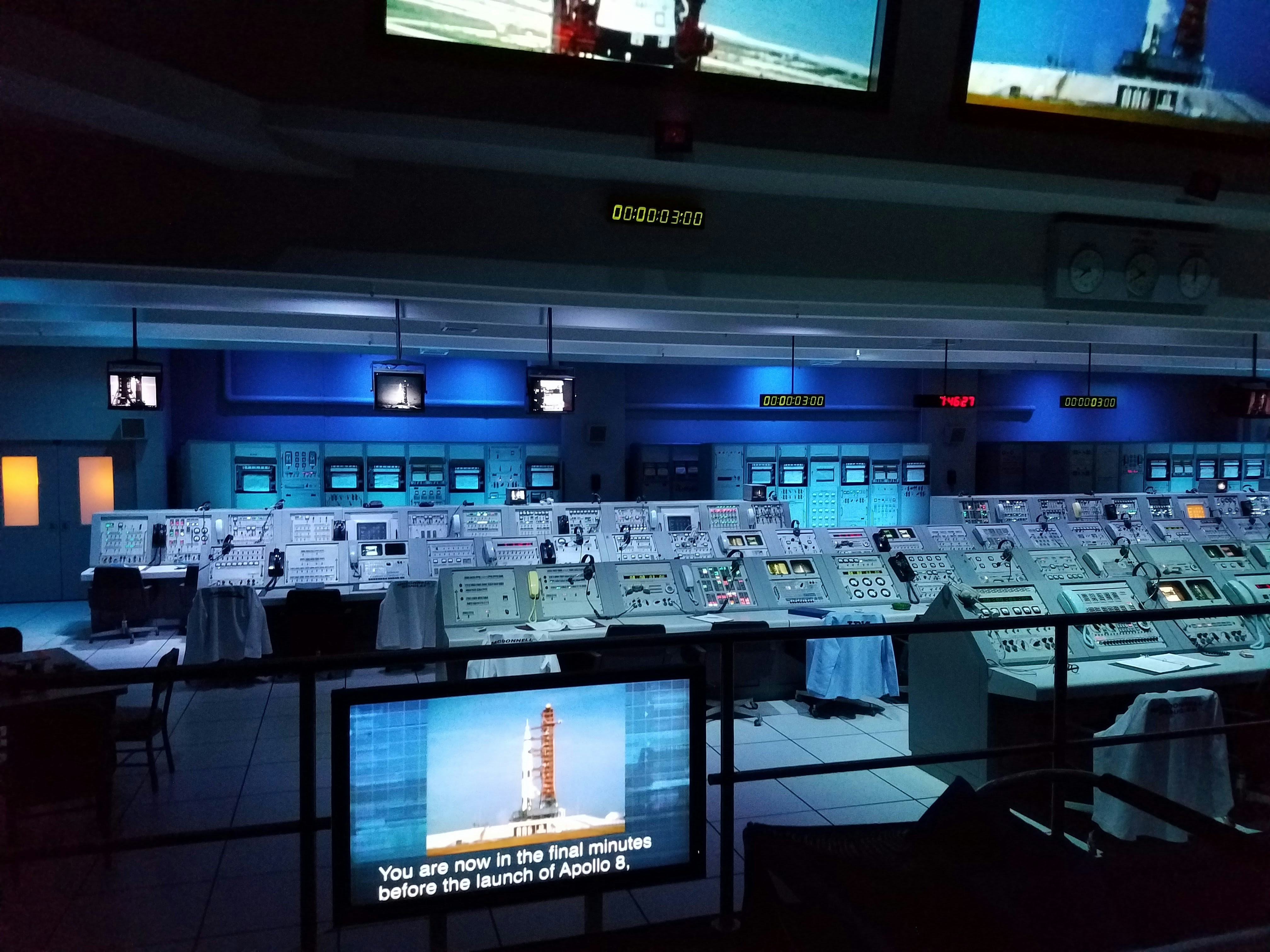 high-tech remote operations center with operators monitoring multiple autonomous cargo ships on large screens