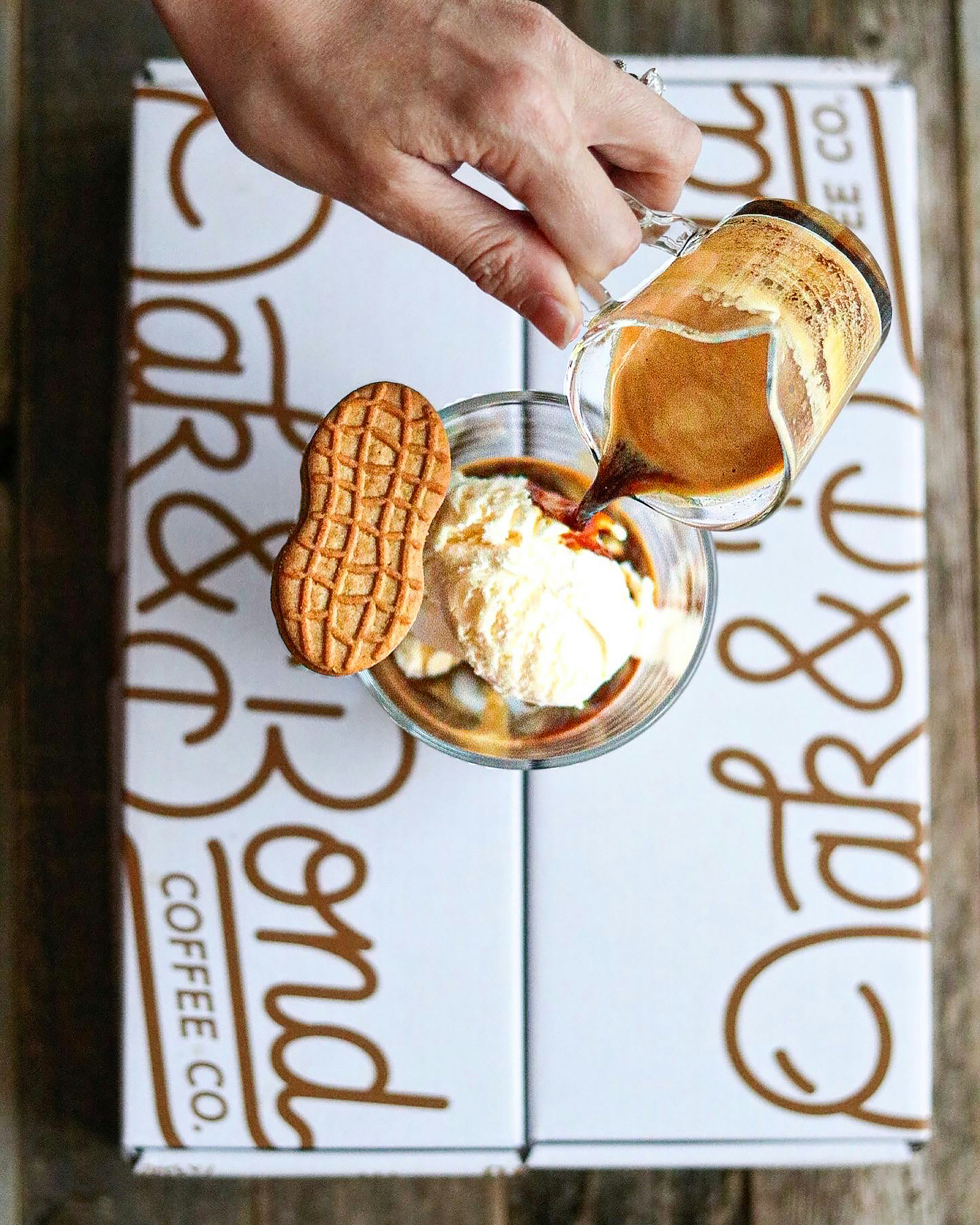 a hand holding a glass of ice cream