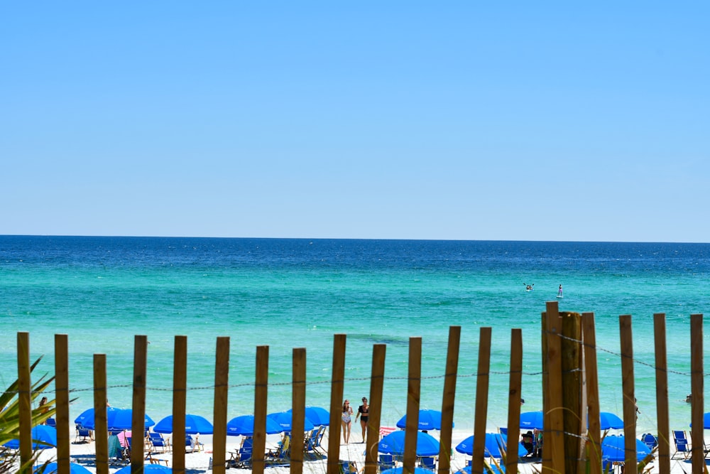 a beach with a fence and a body of water in the background