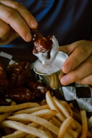 A smiling customer enjoying a big bite of spicy chicken at Drippin Chicken 1.