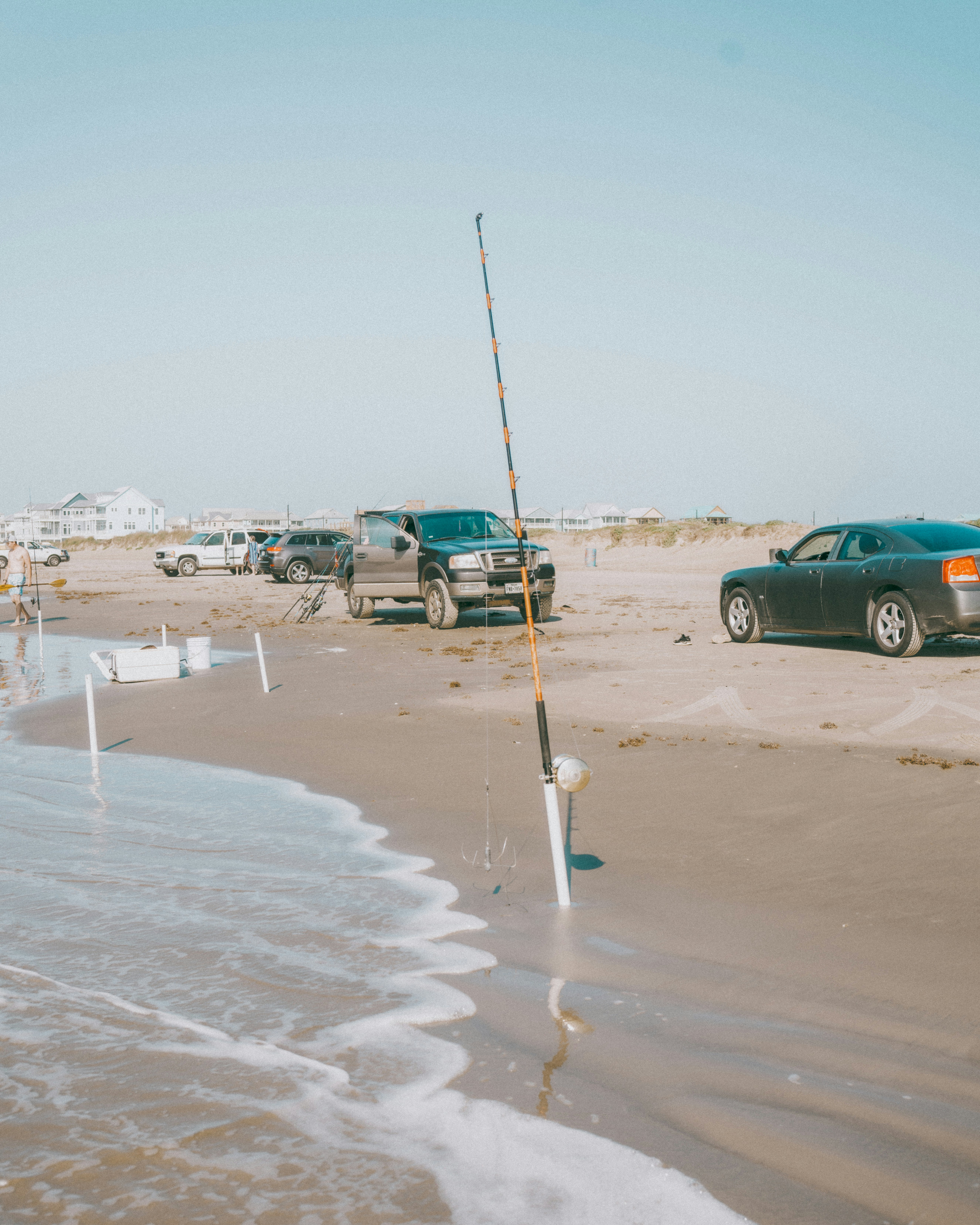 A pole with a stick stuck in the sand