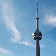 The iconic Monas tower rising against a clear blue sky, with visitors gathered around its base.