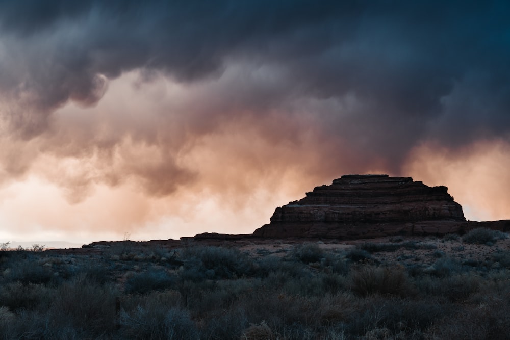 a rocky cliff with a cloudy sky