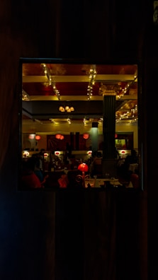 A cozy restaurant interior with warm orange and purple lighting.