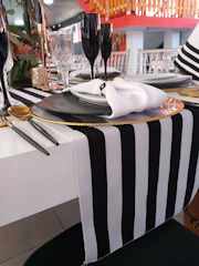 Event setup featuring elegant runners and placemats in charcoal and ivory tones.