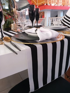 Simple yet stylish black table setting with white linens and glassware.