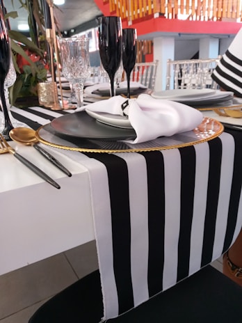 Simple yet stylish black table setting with white linens and glassware.